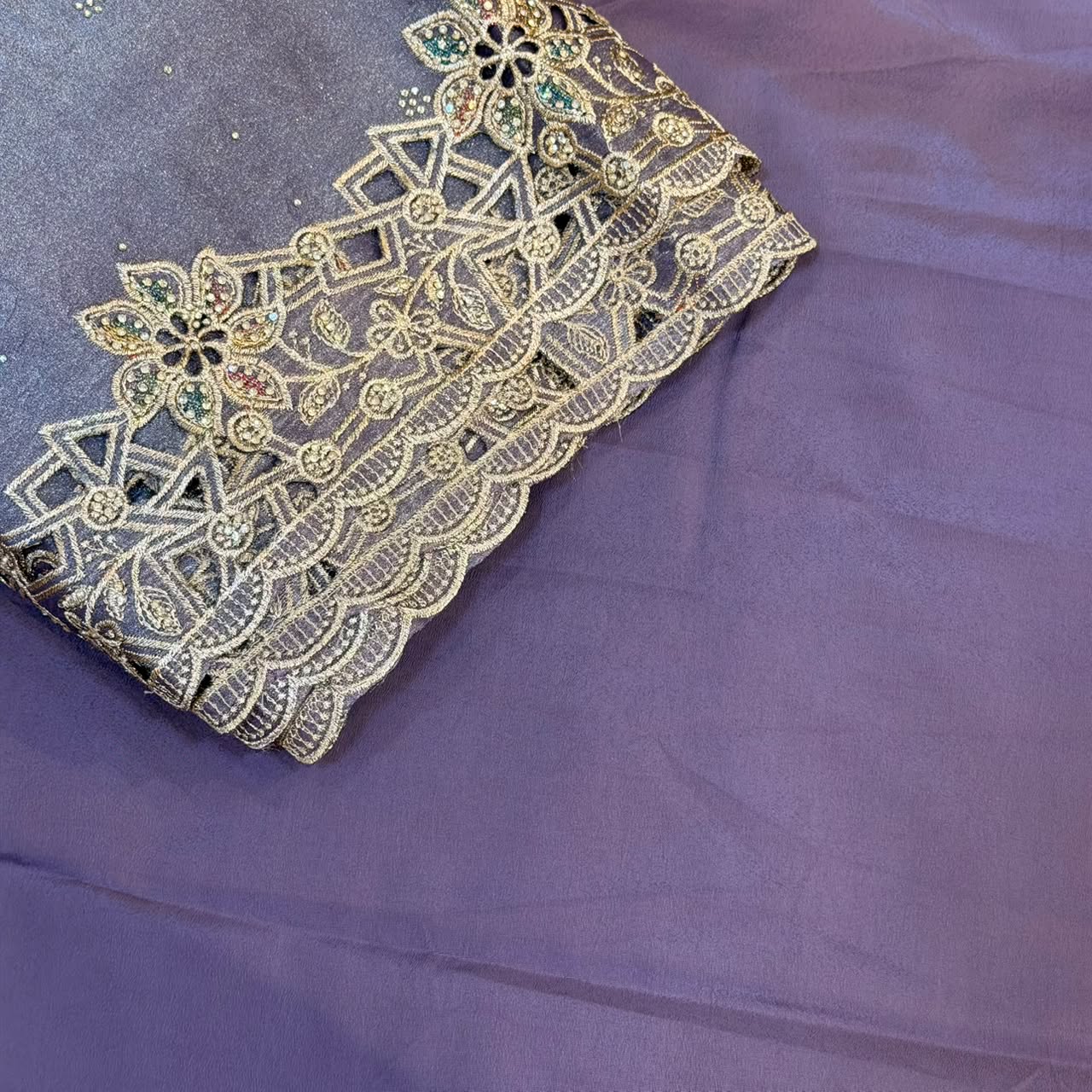 Decorative lace fabric with gold embroidery on a purple background